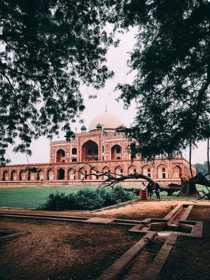A beautifully framed shot of Humayun's Tomb in Delhi, seen through the trees, creating a natural and classic composition.