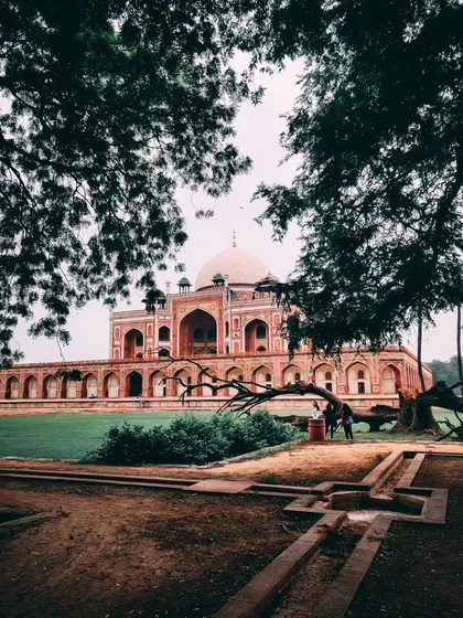 A beautifully framed shot of Humayun's Tomb in Delhi, seen through the trees, creating a natural and classic composition.