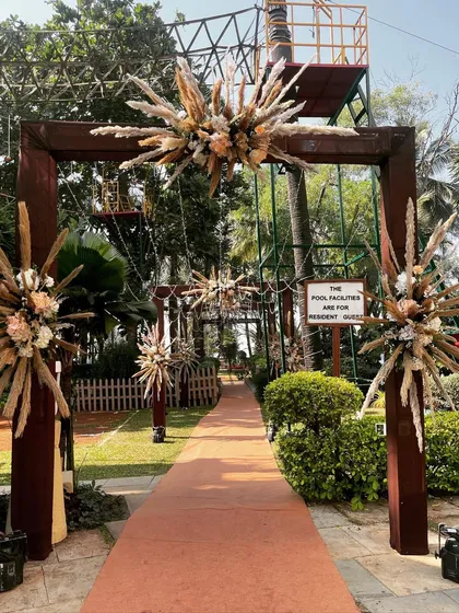 A close-up of the bohemian-style entrance arches. The starburst arrangements of pampas grass and dried flowers are unique and create a stunning textural element in the decor.