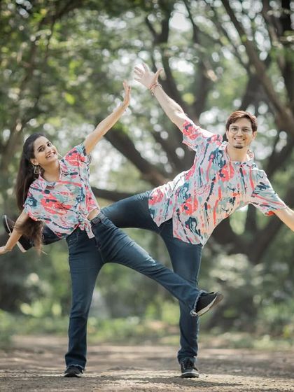 A perfectly synchronized, playful pose in a park. This kind of fun and quirky shot is a great way to showcase your personalities.