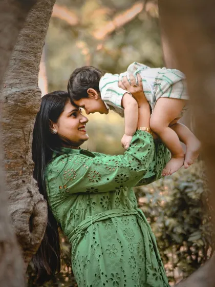 A mother's love captured in an outdoor setting. This beautiful shot of a mom lifting her son into the air is full of joy and tenderness.