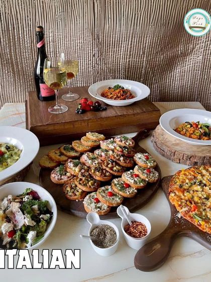 A full Italian feast from our menu. This image displays a variety of our offerings, including pizza, pasta, bruschetta, and salad, perfect for a house party.