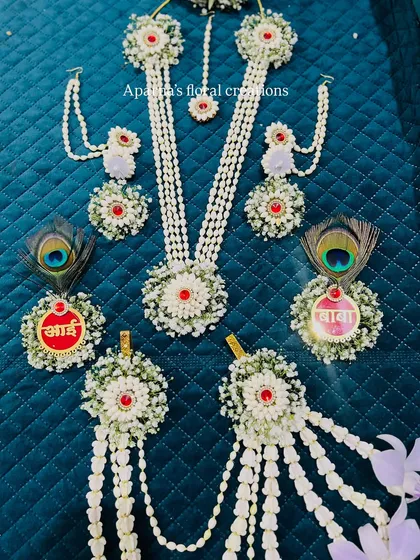 A special touch for baby showers are these custom medallions for the parents-to-be. This set features "आई" (Aai - Mother) and "बाबा" (Baba - Father) medallions, surrounded by fresh flowers and peacock feathers, making the celebration even more personal.