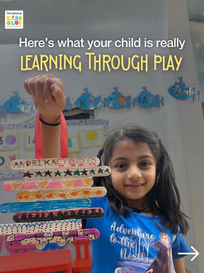 This is what learning through play really looks like. This proud artist is showing off her colorful creation made from simple ice cream sticks, an activity that builds fine motor skills and pattern recognition.