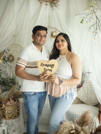 A happy couple holds a "Coming Soon" sign in this casual and modern maternity portrait. Their relaxed outfits and happy smiles make for a lovely announcement.