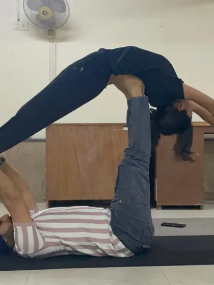 A variation of the 'throne' pose in Acro Yoga, where the flyer is balanced securely on my feet. This pose builds leg strength for the base and core stability for the flyer.