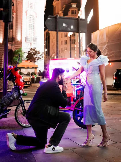 A spontaneous proposal on the streets of London. Her powder blue dress with ruffled shoulders adds a touch of modern romance, while his casual jacket and sneakers keep the moment feeling real and effortless.
