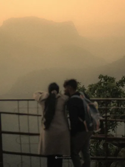 A blurry, atmospheric shot of a couple looking out at the misty mountains, a memory from 2023 that captures a feeling of quiet connection.