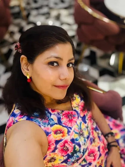 A close-up of my anniversary look. The colorful floral pattern of the dress is complemented by simple red earrings, adding a touch of coordinated elegance to the overall outfit.