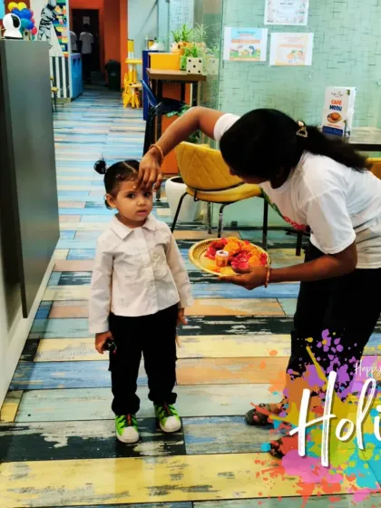 Celebrating Holi, the festival of colors, in a safe and clean way. Here, a staff member applies a gentle tilak to a child.