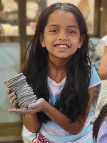 This young artist proudly displays the pot she made using the coil method. This fundamental hand-building technique is one of the first things we teach to help students understand how to build forms with clay.