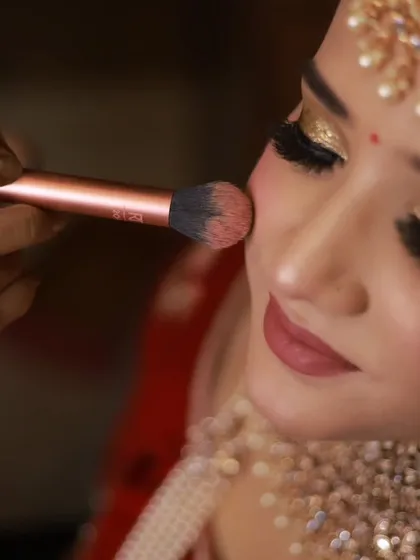 Building that perfect bridal glow. Here, I am applying blush to the apples of the cheeks, a fundamental technique for adding warmth and dimension to the face.