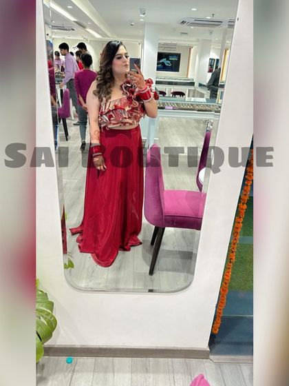 A Karwa Chauth queen taking a mirror selfie in her stunning red floral top and skirt.