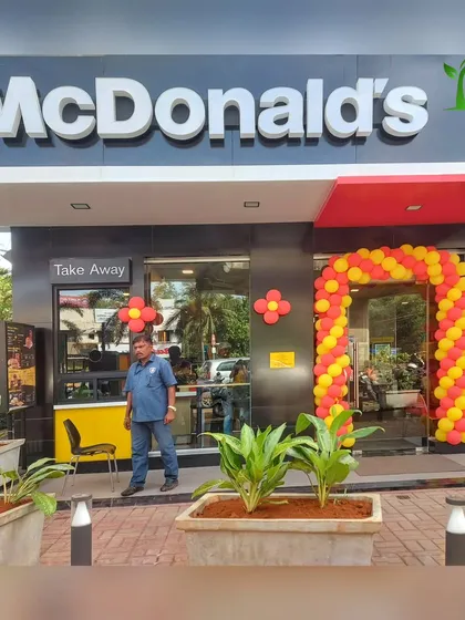 A front view of the McDonald's project, where our founder stands proudly with the newly installed planters. This project shows our capability to handle landscaping for major commercial brands.