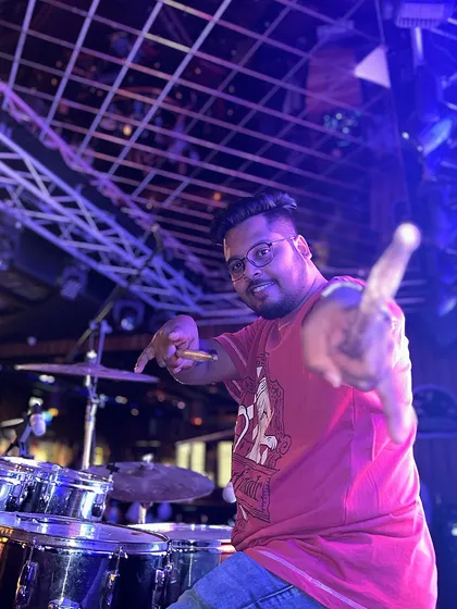 Our passionate drummer, pointing at the camera. He brings the beat to life, with his dynamic energy being the engine of our live shows.