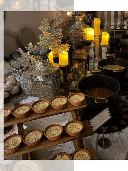 An elegant anniversary buffet with a silver and white theme. The table is aglow with candlelight, creating a romantic and celebratory mood.