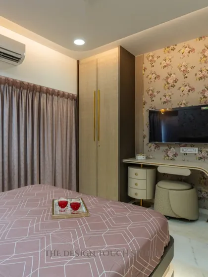 A stylish bedroom featuring a modern wardrobe, a chic bedside table, and a beautiful floral wallpapered accent wall. The space is designed to be both elegant and functional.