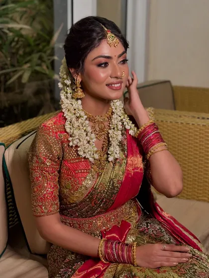 A candid moment showing the bride's serene expression and the intricate details of her temple jewellery and silk saree.