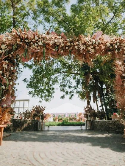 A grand entrance arch made entirely of pampas grass and dried botanicals. This eco-friendly archway set a beautiful, natural tone for the lakeside wedding celebration.