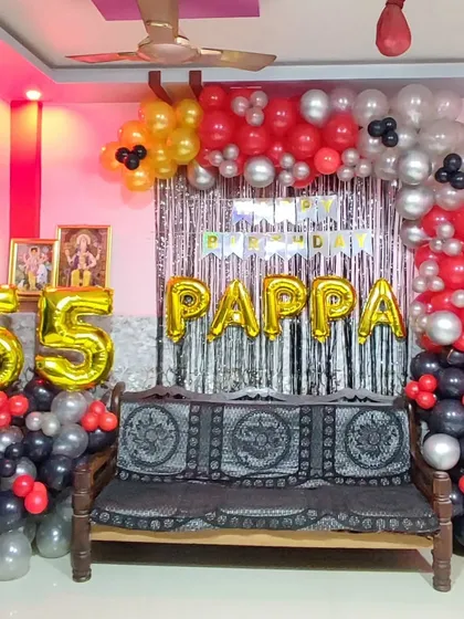 A 55th birthday party for 'Pappa' using a bold red, black, and silver color scheme. The balloon arch is set against a silver shimmer curtain, with large foil numbers celebrating the milestone.
