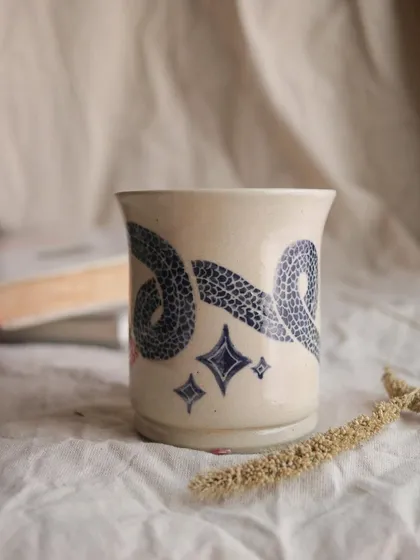 The 'Slithering Time' mug. I used the sgraffito technique on this piece, carving through a layer of color to reveal the clay body underneath. It creates such a beautiful, illustrative effect.