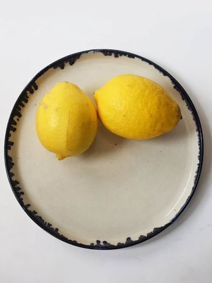 A simple yet elegant dessert plate with a dark, textured rim. The beauty of this piece lies in its understated design, allowing the food served on it to be the star.