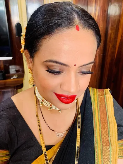 A classic Marathi festival look. This features sharp winged eyeliner, a bold red lip, and a traditional bindi. It’s a timeless style that is perfect for any puja or family celebration.