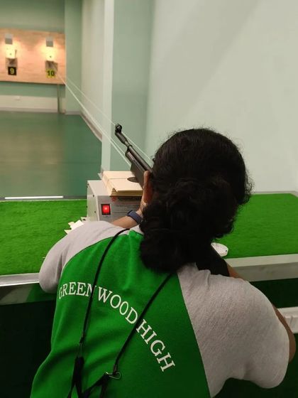 A student from Greenwood High focuses on her target. Our school programs are designed to be holistic, combining live shooting with exercises that improve balance, concentration, and mental calm.