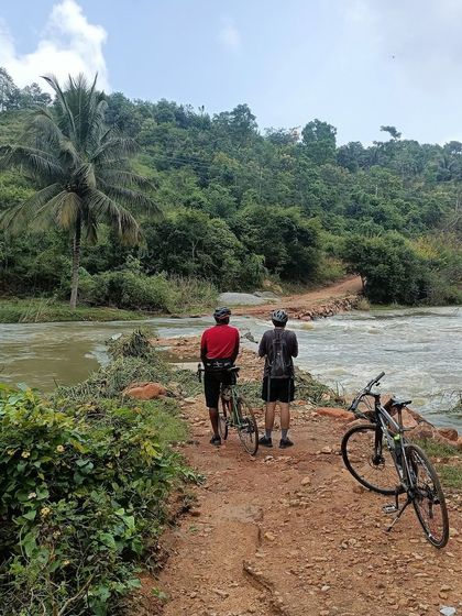 Two riders pause at a causeway with the river flowing over it. Our 'Reservoir Dogs' tour is full of adventurous and scenic moments like this.
