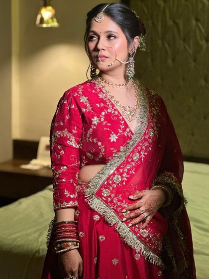 The bride looks serene and beautiful in her red lehenga. The minimal makeup proves that you don't need heavy layers to make a statement.