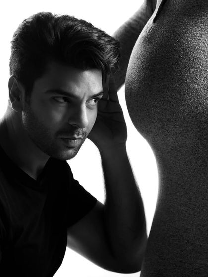 "Is anyone in there?" A playful and intimate black and white portrait that captures the curiosity and excitement of a dad-to-be.