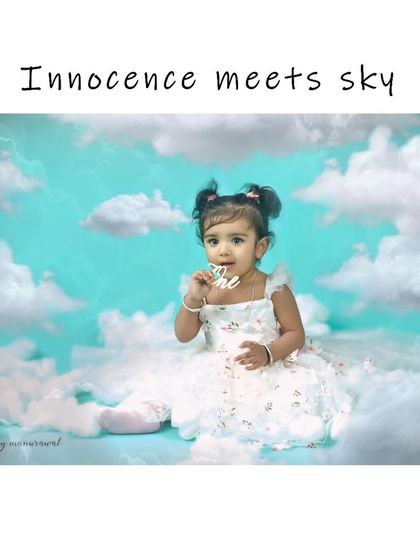 "Innocence meets sky" in this dreamy, cloud-themed sitter session. Dressed in a beautiful white dress, this little girl looks like an angel floating in a soft, blue sky.