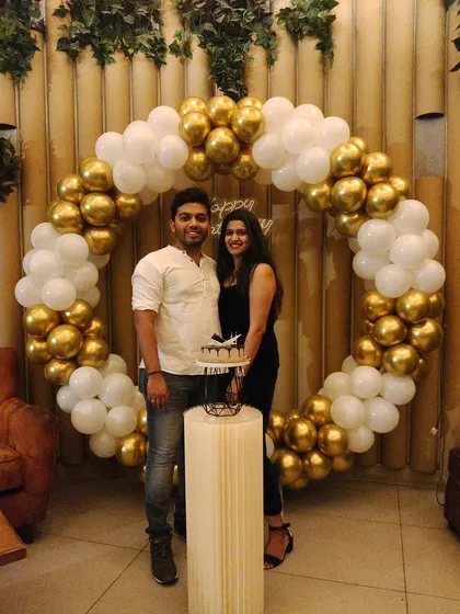 A picture perfect moment for the happy couple in front of a classic white and gold balloon ring I set up for a birthday celebration at a Bengaluru cafe.