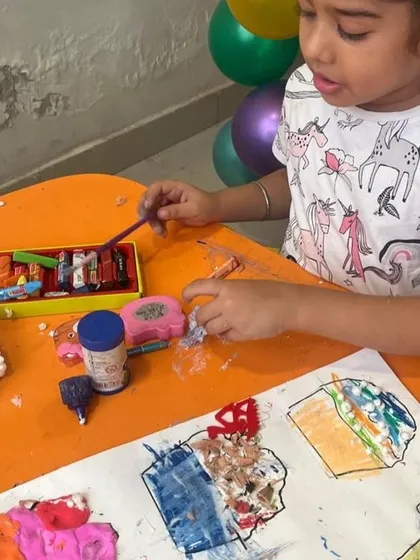 A student explores different materials like foam and clay to decorate her cupcake drawings. Our mixed-media projects are all about experimentation and creative freedom.