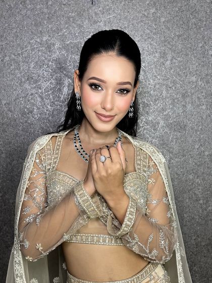 Beauty is power, and glam makeup is its weapon. This client looks stunning with her sleek ponytail, smokey eyes, and radiant skin.