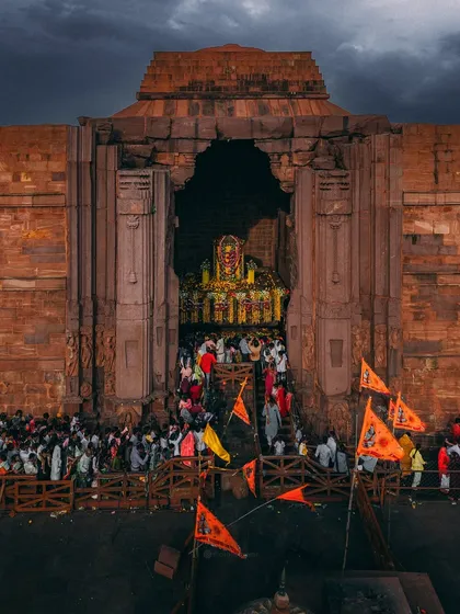 Devotees with saffron flags throng the entrance of the Bhojpur Shiva Temple, a powerful display of faith at this historic site.