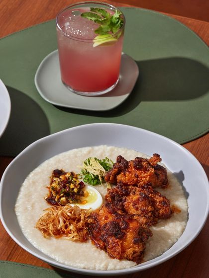Our Hot Fried Chicken Congee, a comforting bowl of rice porridge with crispy five-spice chicken, a soft onsen egg, and a ginger scallion dip.