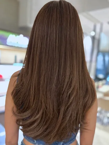 A complete hair color transformation from warm auburn to a cool brown and beige blend. I added long face-framing layers and styled it straight to showcase the sleek new color.