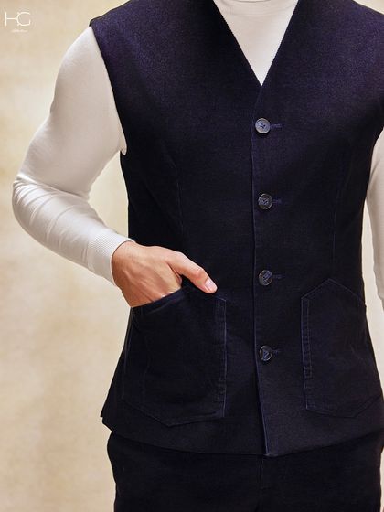 The corduroy waistcoat is a versatile piece on its own. Here it is layered over a turtleneck, showing off its patch pockets and tailored fit.