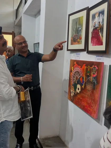 Pointing out the details in a watercolour painting to Shri Ajay Purkar at the exhibition.