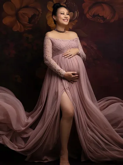 A moment of pure joy and anticipation. This mama-to-be looks absolutely radiant in a dusty pink lace and tulle gown, with the flowing fabric adding a touch of drama and elegance.