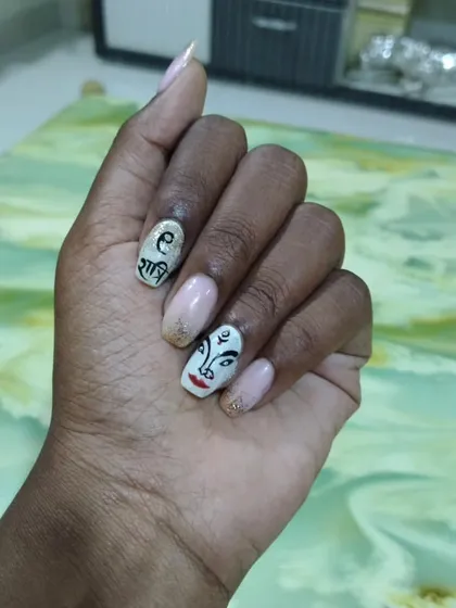 For Navratri, I created this special set featuring a hand-painted Devi Maa face and "Shakti" written in Devanagari script. I love making unique festive nail art that helps you celebrate in style. This design is done with gel polish on natural nails with a touch of gold glitter.