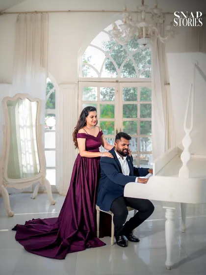 A romantic moment by a white grand piano, set against a sunlit window. This setup is perfect for couples looking for an elegant and classic pre-wedding theme.