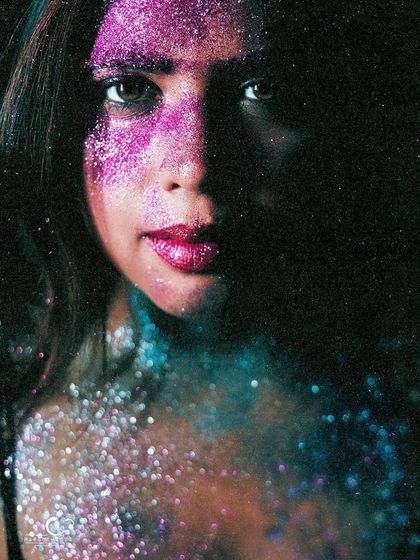 A dramatic portrait with half her face in shadow. The glitter catches the light, creating a beautiful contrast between light and dark.