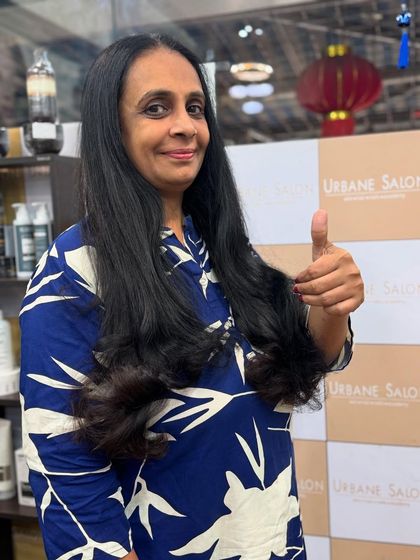 A happy client giving a thumbs-up for her new long layered haircut. We love seeing those smiles.