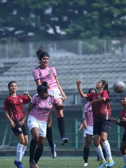 A player airborne, challenging for a header against an opponent.