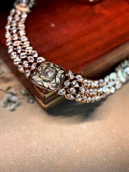 A delicate three-strand polki bracelet with an intricately carved central clasp, perfect for a subtle touch of luxury.