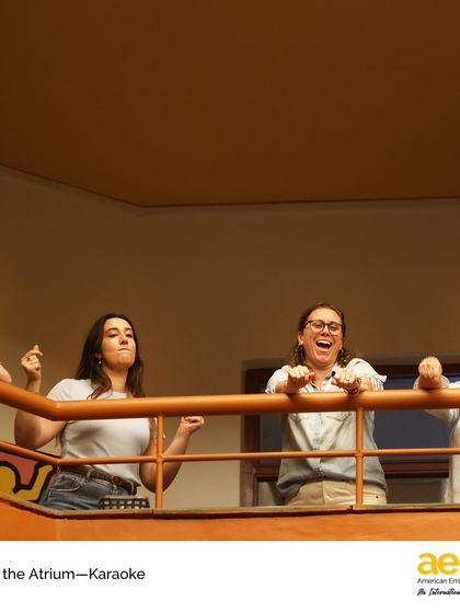 Teachers and staff enjoy the show from the balcony, singing along with the performers. 'Arts in the Atrium' events are a true community affair, bringing everyone together.