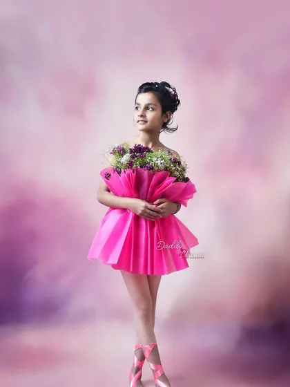 A thoughtful pose from the ballerina-themed shoot, where the girl looks to the side while holding her bouquet. This highlights a different mood and expression.