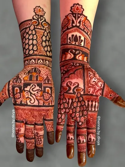A majestic bridal design featuring a grand Ganesha on one palm and intricate peacock and palace art on the other. The arms are covered in dense, traditional patterns.